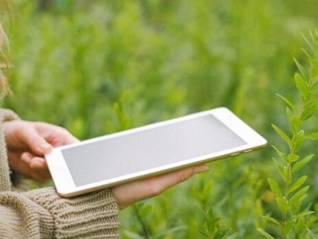 Cidade sustentável com prédios verdes, energia solar e turbinas eólicas, simbolizando a contribuição da tecnologia para um futuro ambientalmente responsável.